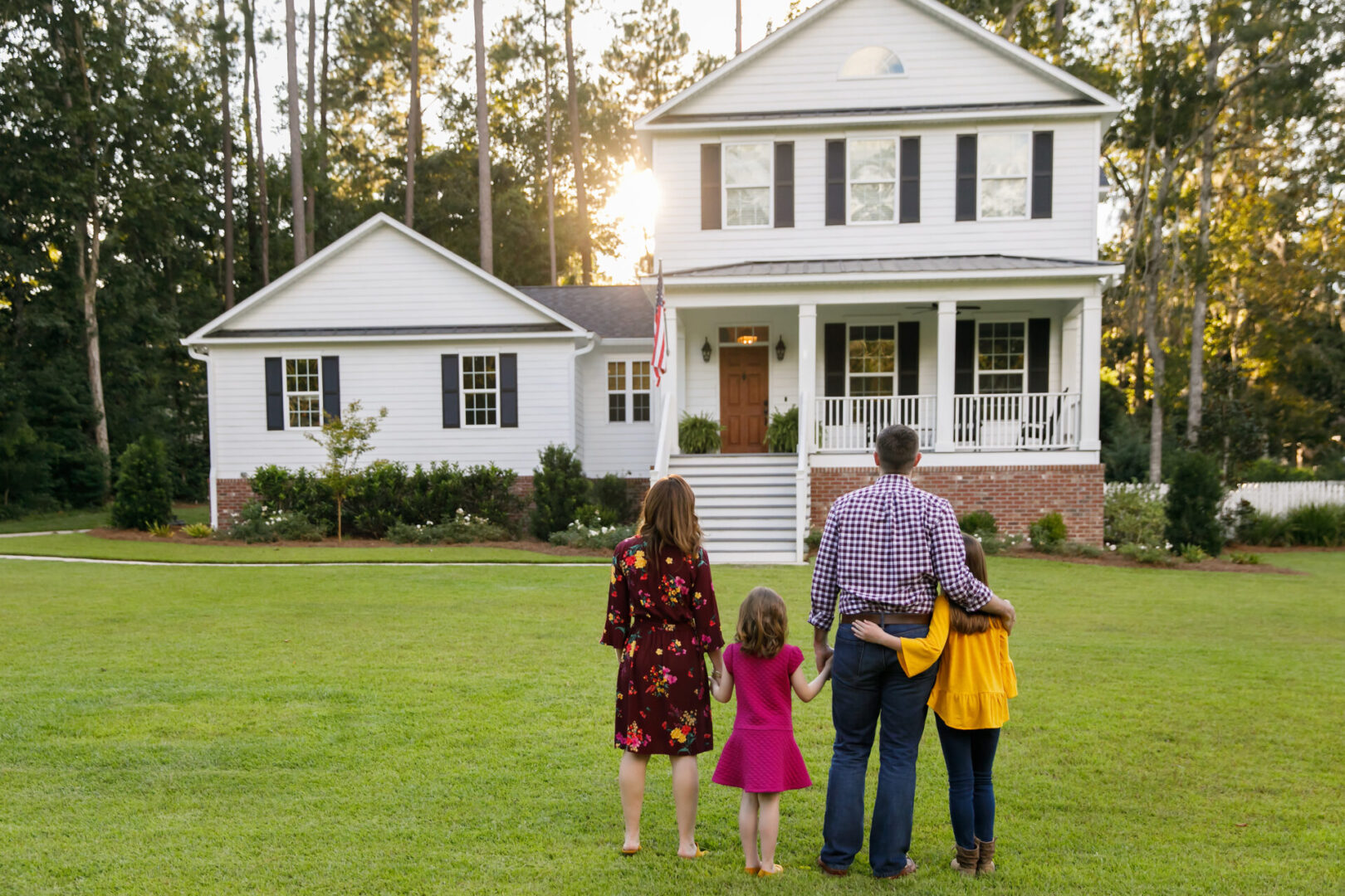 Family of Four With Daughters Looking at Their New Construction